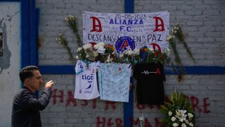 Flowers are left on a mural for those killed in stampede outside the Cuscatlan Stadium, in San Salvador, El Salvador, on May 22, 2023.