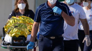 Paramedics carry an injured survivor of a shipwreck to an ambulance at the port in Kalamata town, about 240 kilometers (150 miles) southwest of Athens, Wednesday, June 14, 2023.