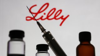 Medical bottles and syringe are seen with Eli Lilly and Company logo displayed on a screen in the background in this illustration photo taken in Krakow, Poland on November 10, 2022. (Photo by Jakub Porzycki/NurPhoto via Getty Images)