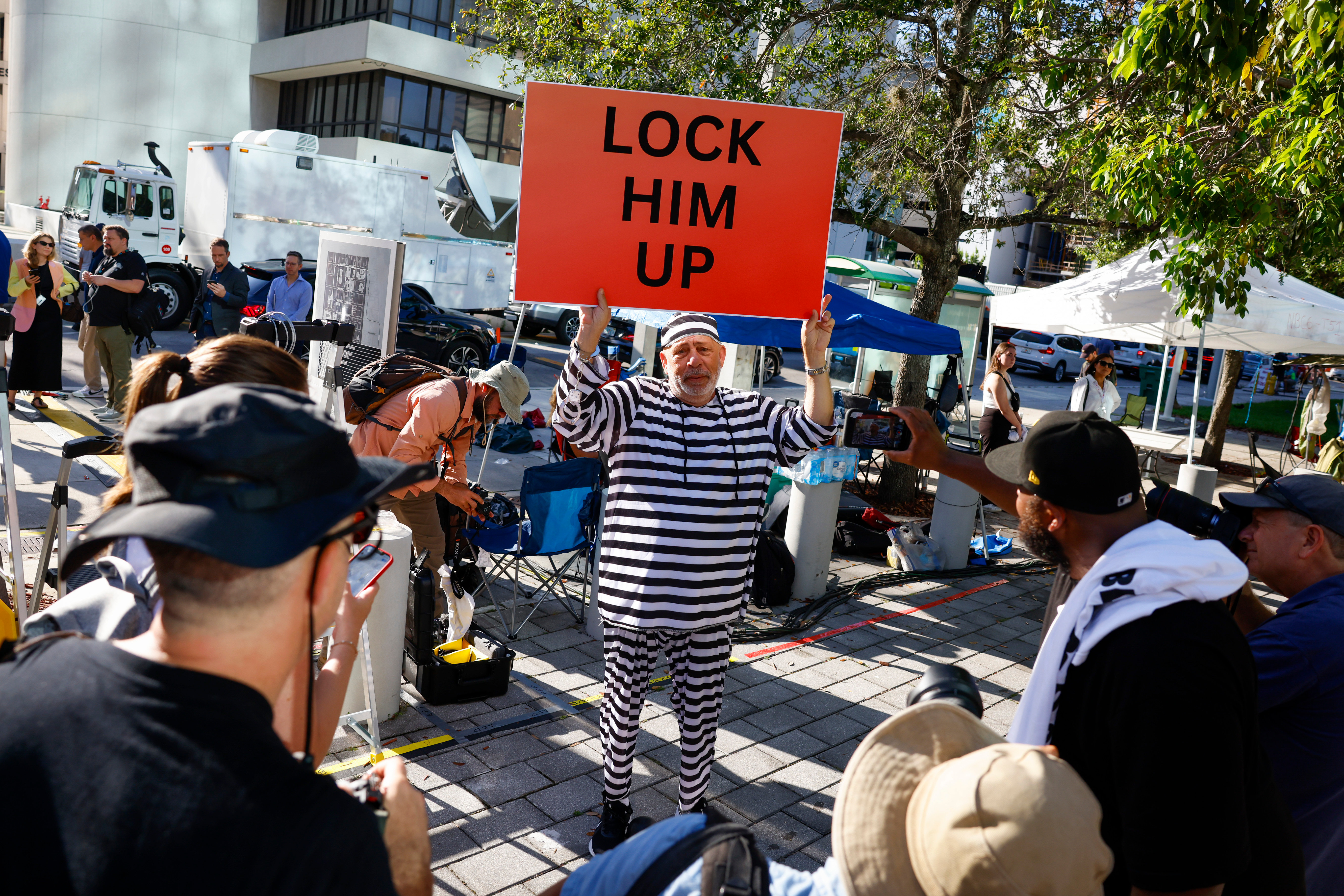 A protestor holds a “Lock Him Up” sign outside the Wilkie D. Ferguson Jr. United States Courthouse in Miami, Florida, June 13, 2023. Former President Donald Trump is due in a Miami federal court to face charges alleging he jeopardized national security by violating the Espionage Act, even as he leads the Republican field for next year’s presidential race.