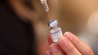 A nurse prepares doses of the Pfizer vaccine during a COVID-19 vaccination event at Josephine’s Southern Cooking in Chatham, Illinois, Dec. 30, 2021.