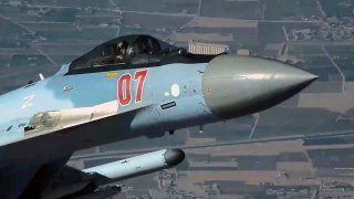 In this image from video released by the U.S. Air Force, a Russian fighter jet flies close to a U.S. drone over Syria, July 23, 2023. A Russian fighter jet flew within a few meters of a U.S. drone over Syria and fired flares at it, striking the American aircraft and damaging it, the U.S. military said Tuesday, the latest in a string of aggressive intercepts by Russia in the region.