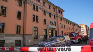 A firefighter truck and a police car are parked outside the “Casa per Coniugi” nursing home where a fire broke out overnight causing the death of six people in Milan, Italy, Friday, July 7, 2023.