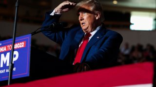 Former U.S. President and Republican presidential candidate Donald Trump covers his face from lights as he holds a campaign rally in Erie, Pennsylvania, U.S., July 29, 2023. 