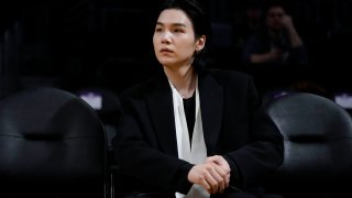 FILE – BTS member Suga attends an NBA basketball game between the Los Angeles Lakers and the Dallas Mavericks on Jan. 12, 2023, in Los Angeles. Suga has become the third member of BTS to begin South Korea’s compulsory military service. BTS’ label, Big Hit Music, said in a statement on Monday, Aug. 7, 2023, that Suga “has initiated the military enlistment process by applying for the termination of his enlistment postponement.”