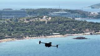 A long-range drone equipped with thermal imaging cameras and a sophisticated early warning system patrols over Kavouri beach and nearby woodland, in southern Athens, Greece, Thursday, Aug. 17, 2023. Greece is plagued by hundreds of wildfires each summer. To protect their area from potentially deadly blazes, a group of residents from a suburb in northern Athens have joined forces to hire a company using long-range drones equipped with thermal imaging cameras and a sophisticated early warning system to catch fires before they can spread. (AP Photo/Thanassis Stavrakis)