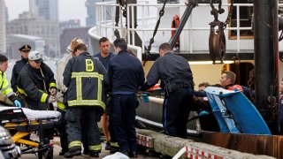 First responders remove a man from the fishing vessel America onto land in Boston on Tuesday, Sept. 26, 2023. Crew from America said they happened upon the man in the ocean.