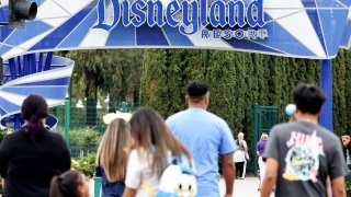 People walk toward an entrance to Disneyland on April 24, 2023 in Anaheim, California.