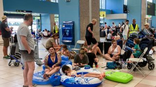 Tourists wait in the airport during wildfire evacuations on the Greek island of Rhodes on July 23, 2023.