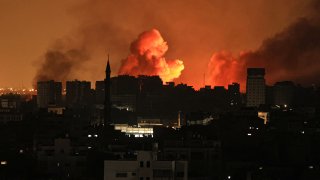 A ball of fire erupts in Gaza City after an Israeli air strike on October 12, 2023. Israel has vowed to “crush” Hamas after gunmen from the Palestinian Islamist group stormed across the border and killed 1,200 people — the deadliest attack on the country since it was founded 75 years ago.