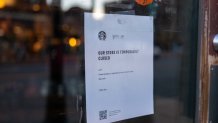 A sign on a Starbucks restaurant announces it is temporarily closed as people shelter in place following a mass shooting and subsequent manhunt on Oct. 26, 2023 in Portland, Maine.