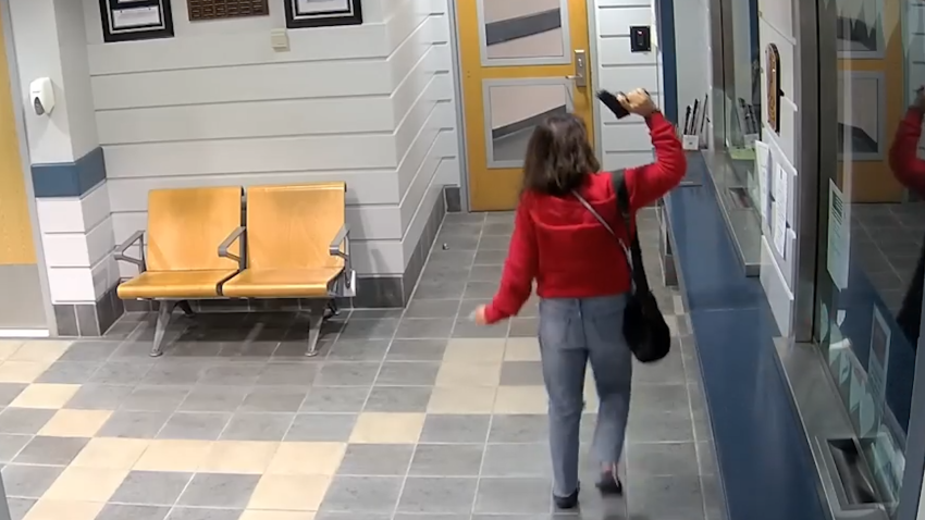 Woman in lobby of police station holding gun