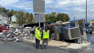 A rolled-over truck that spilled trash or scrap in Revere, Massachusetts, on Tuesday, Oct. 10, 2023.