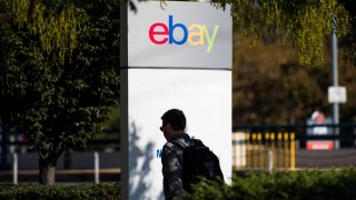 An employee walks past eBay signage at the company’s headquarters in San Jose, California.