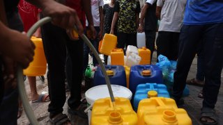 Palestinians queue to refill on water in Rafah refugee camp in the southern of Gaza Strip, on October 14, 2023.