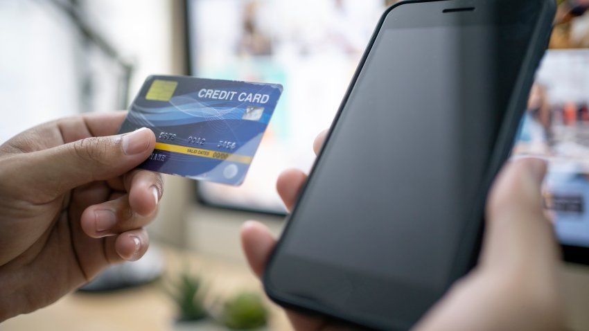 Hands holding a credit card and using smart phone for online shopping