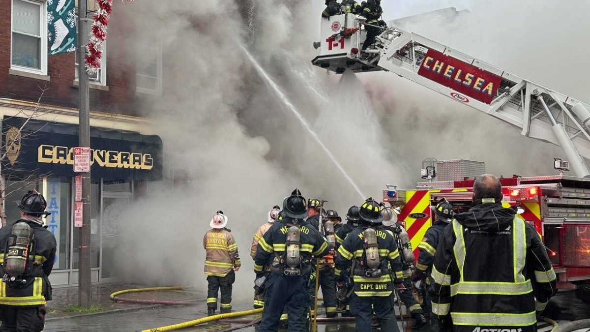 切尔西百老汇街上的消防员与熊熊大火搏斗，浓烟滚滚上升