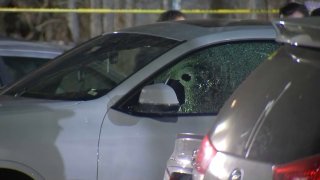 A car damaged by gunfire on Academy Road in Boston’s Roxbury neighborhood Friday.