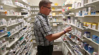 Pharmacist Thomas Jensen looks over a prescription drug at the Rock Canyon Pharmacy in Provo, Utah, on May 9, 2019.