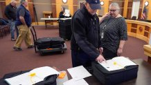 Public witness David Lahey, of Derry, N.H. confirms the serial number of a ballot counting machine with Tina Guilford, Derry town clerk, right, while testing vote counting machines before New Hampshire primary.