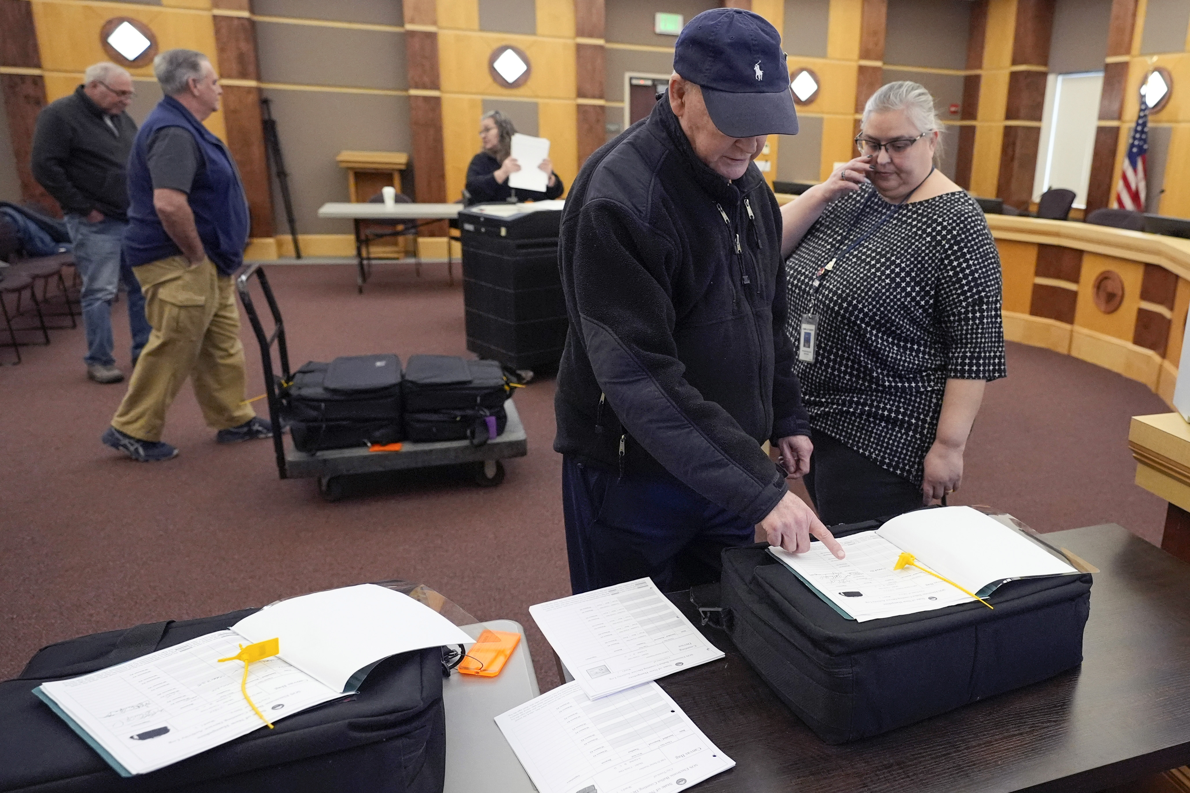 Public witness David Lahey, of Derry, N.H. confirms the serial number of a ballot counting machine with Tina Guilford, Derry town clerk, right, while testing vote counting machines before New Hampshire primary.