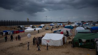 Palestinians displaced by the Israeli air and ground offensive on the Gaza Strip walk through a makeshift tent camp in Rafah on Saturday, Jan. 27, 2024.