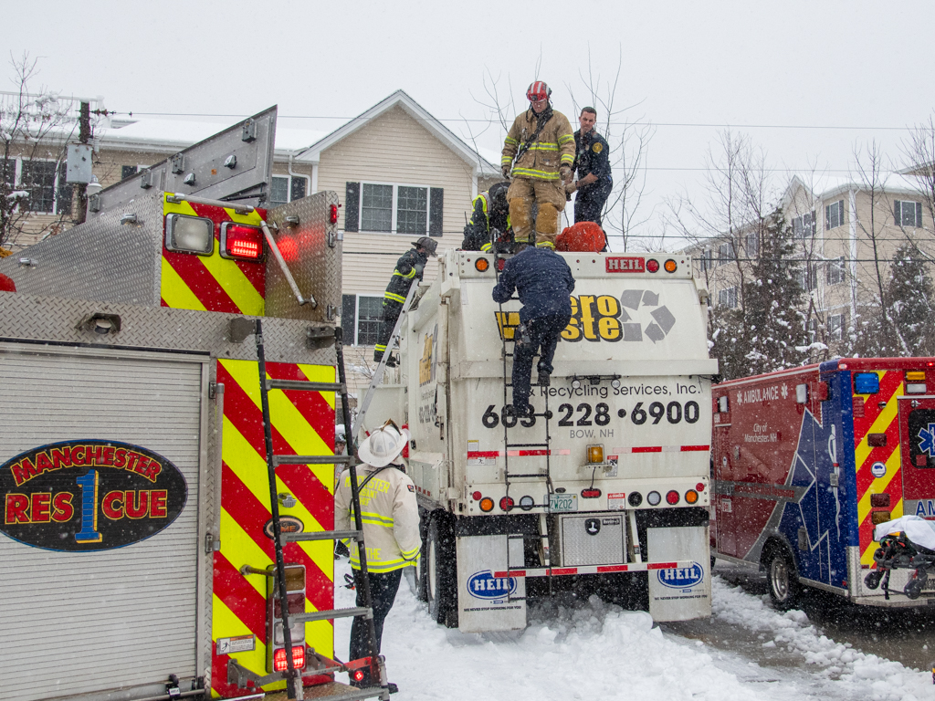 First responders atop a sanitation truck that a woman was trapped inside in Manchester, New Hampshire, on Monday, Jan. 29, 2024.