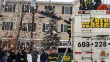 A woman being hoisted from a sanitation truck she'd been trapped inside in Manchester, New Hampshire, on Monday, Jan. 29, 2024.