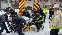 A woman being stretchered away from a sanitation truck she'd been trapped inside in Manchester, New Hampshire, on Monday, Jan. 29, 2024.