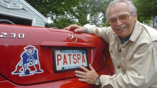 This 2009 photo shows Patriots logo creator Phil Bissell outside his home studio in Rockport, Massachusetts, posing with his car, adorned with the logo and a vanity plate reading, "PATSPA."
