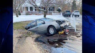 A car that was swallowed up by a sinkhole in Attleboro, Massachusetts, after hitting a fire hydrant.