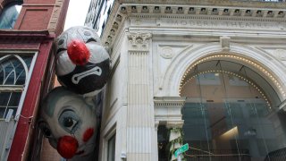 An art exhibition consisting of two giant clown heads between two buildings in Boston's Downtown Crossing.