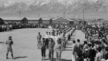 In this photo provided by the National Archives, Japanese Americans, including American Legion members and Boy Scouts, participate in Memorial Day services at the Manzanar Relocation Center, an internment camp in Manzanar, Calif., on May 31, 1942. (Francis Leroy Stewart/War Relocation Authority/National Archives via AP)