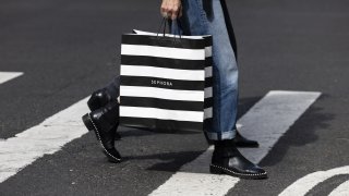 A file photo of a person carrying a Sephora bag across a street.