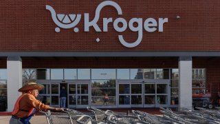 A worker pushes shopping carts outside a Kroger grocery store in Dallas, Texas, Feb. 21, 2024.