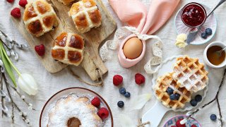 Easter festive dessert table with hot cross buns, cakes, waffles and pancakes