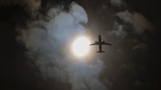 An airplane passes during a partial solar eclipse seen from Queens, New York City, U.S., April 8, 2024. 