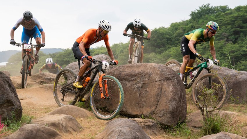 Multiple riders race on a mountain bike course