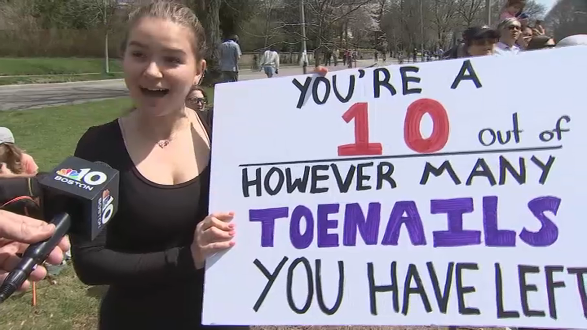 A Boston Marathon spectator at Heartbreak Hill in Newton, Massachusetts, holds a sign that reads, "You're a 10 out of however many toenails you have left."