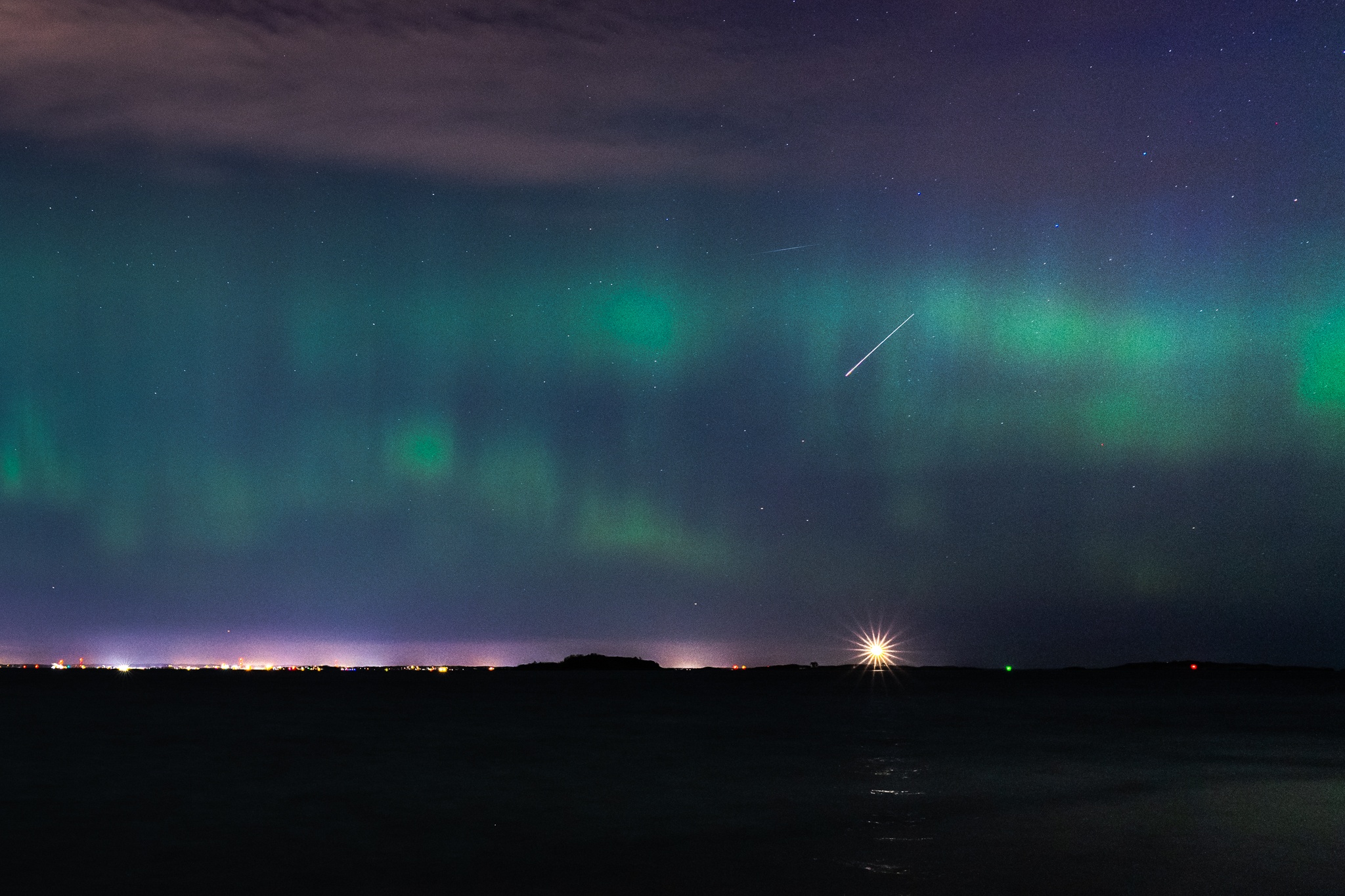 Photo of the Boston Light Lighthouse under the northernlight while a meteor crossed by