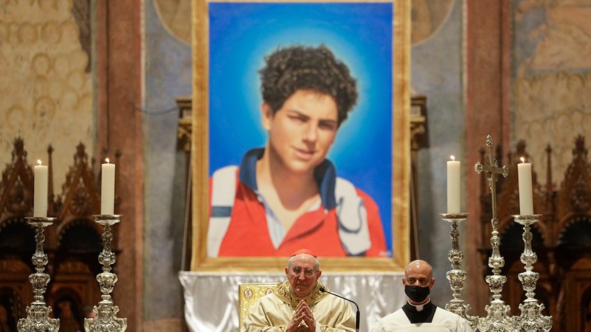 FILE – An image of 15-year-old Carlo Acutis, an Italian boy who died in 2006 of leukemia, is seen during his beatification ceremony celebrated by Cardinal Agostino Vallini, center, in the St. Francis Basilica, in Assisi, Italy, on Oct. 10, 2020. Pope Francis has paved the way for the canonization of the first saint of the millennial generation on Thursday, attributing a second miracle to a 15-year-old Italian computer whiz who died of leukemia in 2006. Carlo Acutis, born on May 3, 1991, in London and then moved with his Italian parents to Milan as a child, was the youngest contemporary person to be beatified by Francis in Assisi in 2020.