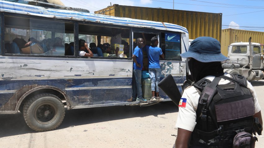 A bus passes by a police officer on patrol near the airport in Port-au-Prince, Haiti, Friday, May 24, 2024.