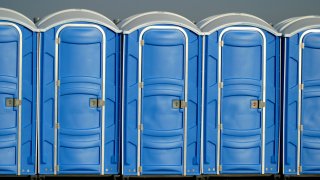 Row of portapotties at an outdoor event.