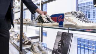 An employee adjusts a sneaker display inside a Golden Goose SpA store in the Mayfair district of London, UK, on Monday, Dec. 4, 2023. Roughly a dozen banks competed for roles on a potential initial public offering in Milan of Golden Goose, with valuations pitched in a range of 3 billion ($3.3 billion) to 4 billion. Photographer: Jason Alden/Bloomberg via Getty Images