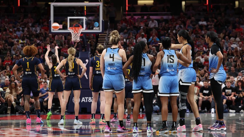 Caitlin Clark shoots a free throw as players look on