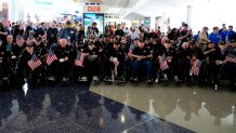 A group of World War II veterans wait to board a plane at Dallas Fort Worth International Airport in Dallas, Texas, Friday, May 31, 2024. 