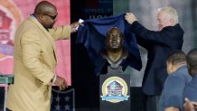 FILE - Former NFL football player Larry Allen, left, and Dallas Cowboys owner Jerry Jones unveil the bust of Allen during the induction ceremony at the Pro Football Hall of Fame, Aug. 3, 2013, in Canton, Ohio. Allen, one of the most dominant offensive linemen in the NFL during a 12-year career spent mostly with the Dallas Cowboys, died suddenly on Sunday, June 2, 2024, while on vacation with his family in Mexico, the Cowboys said. He was 52.