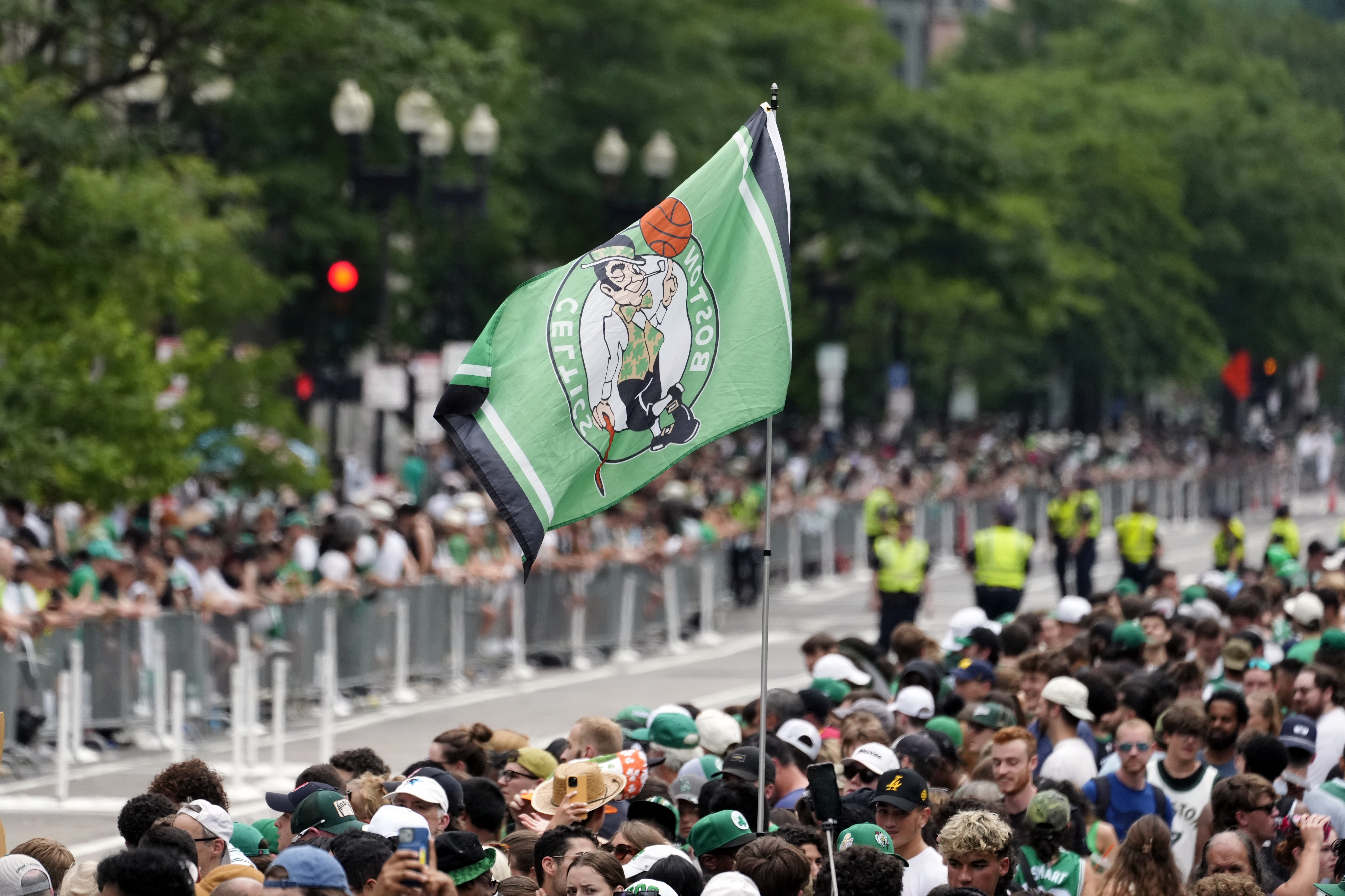 A Boston Celtics banner flies above the crowd in Copley Square along the route of the parade.