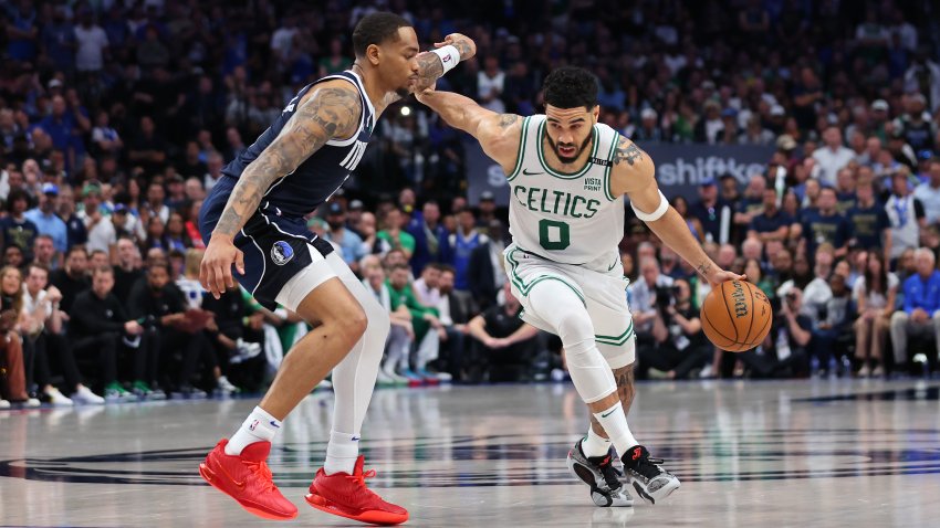 Jayson Tatum #0 of the Boston Celtics dribbles the ball while being guarded by P.J. Washington #25 of the Dallas Mavericks in the fourth quarter in Game Three of the 2024 NBA Finals at American Airlines Center on June 12, 2024 in Dallas, Texas.