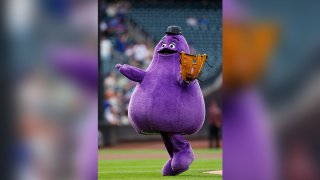 The McDonald’s Grimace throws out the first pitch before a baseball game between the Miami Marlins and New York Mets, Wednesday, June 12, 2024, in New York.